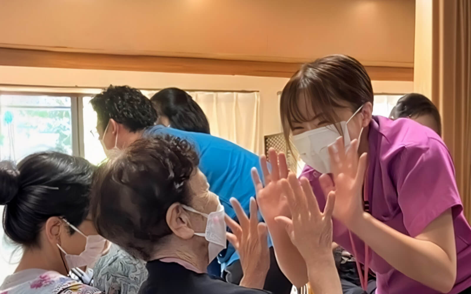 利用者とスタッフが笑顔でハイタッチしている様子